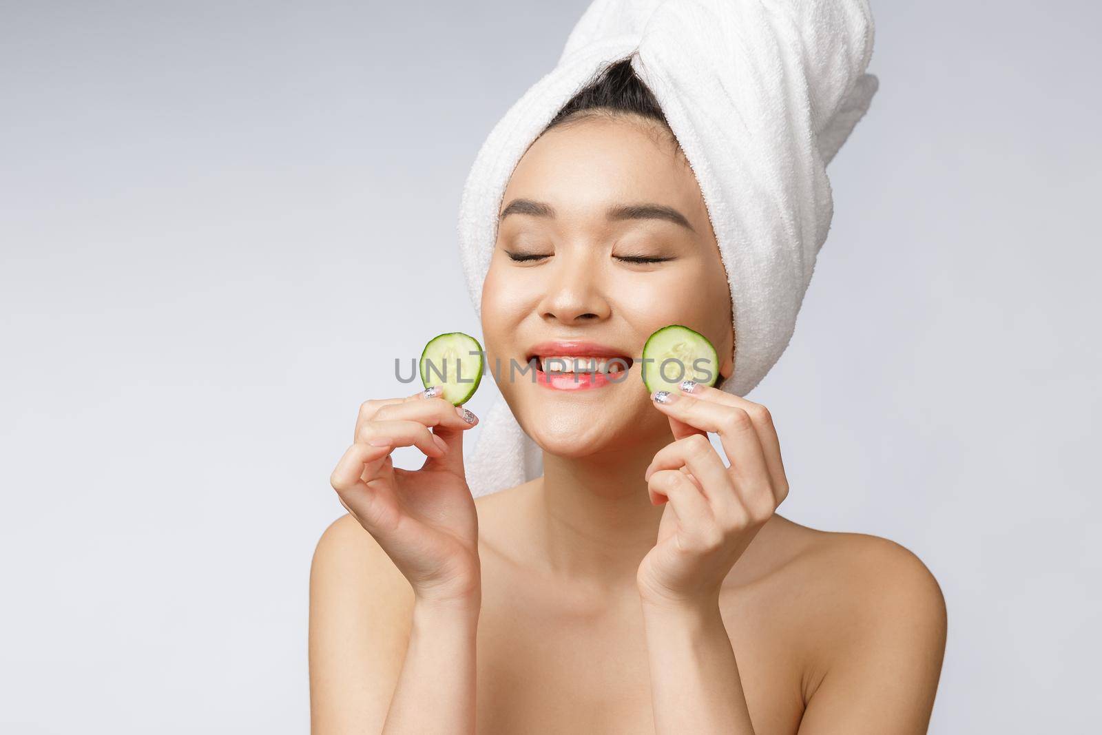 Beauty young asian women skin care image with cucumber on white background studio