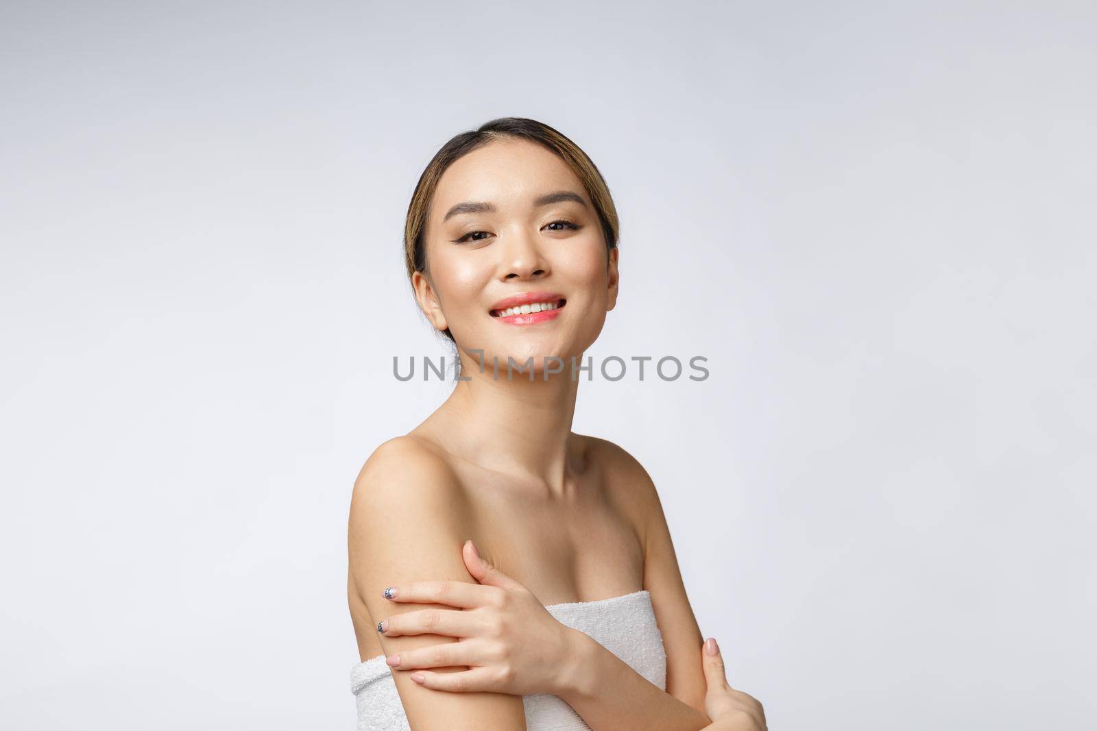 Sided portrait of Asian beautiful smiling girl with short hair showing her healthy skin on the isolated white background.
