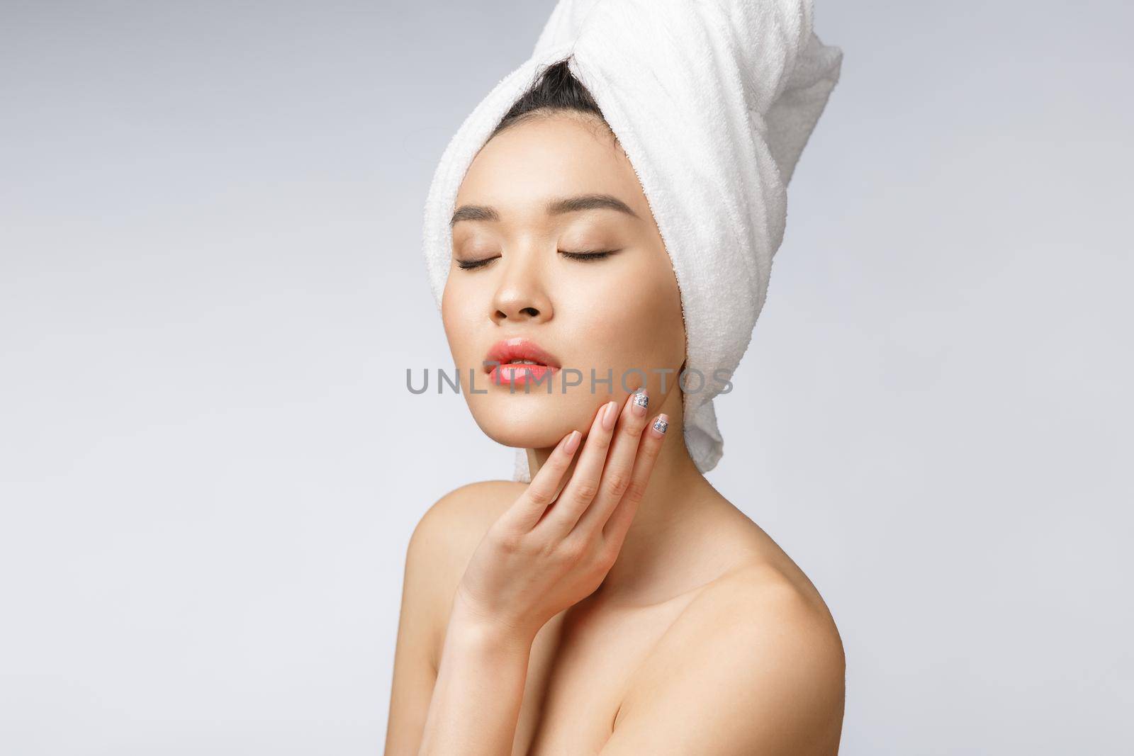 Sided portrait of Asian beautiful smiling girl with short hair showing her healthy skin on the isolated white background.