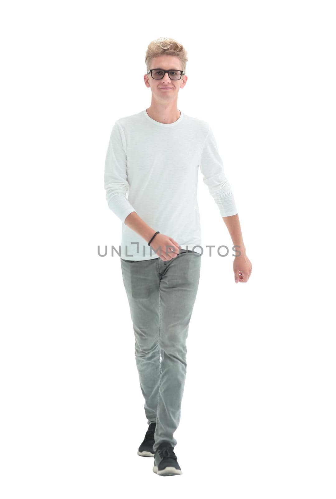in full growth. confident young man striding forward. isolated on white