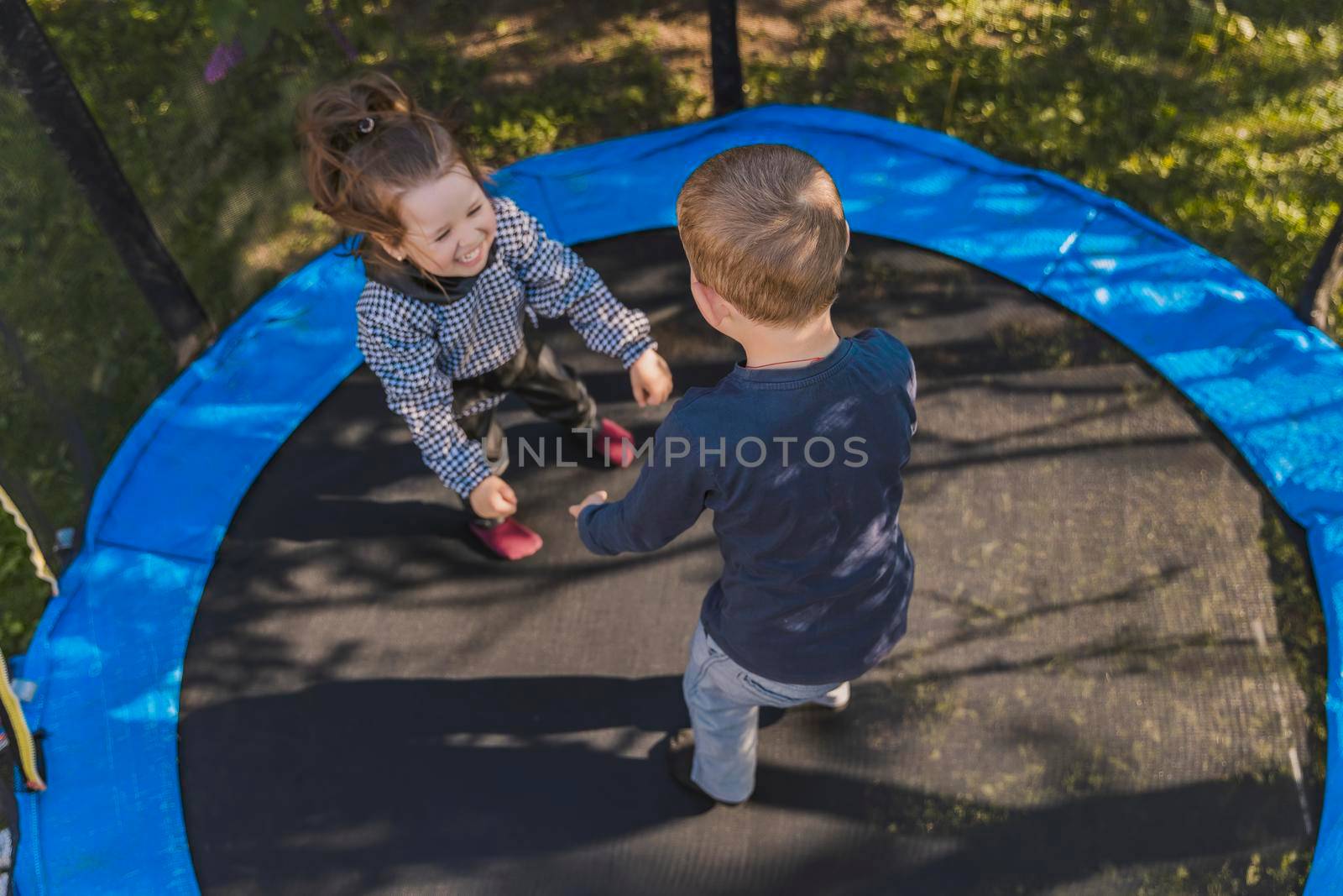 children jumping on a trampoline top view