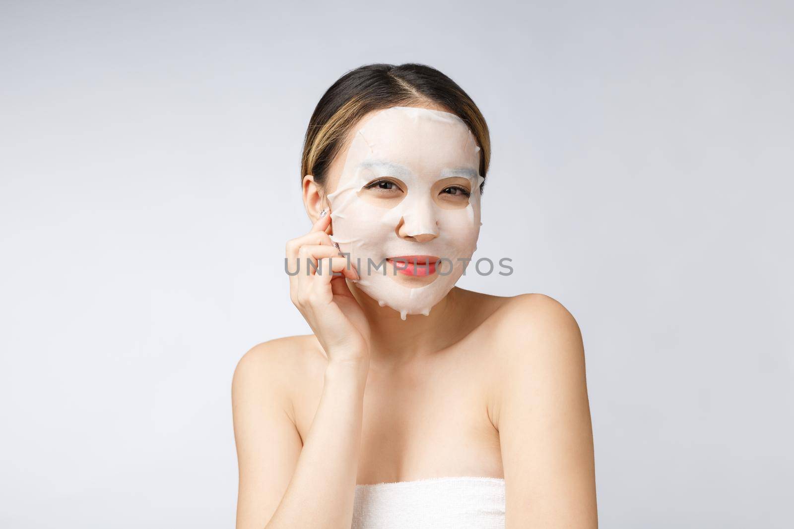 Spa, healthcare. Asian girl with a cosmetic mask isolate on white