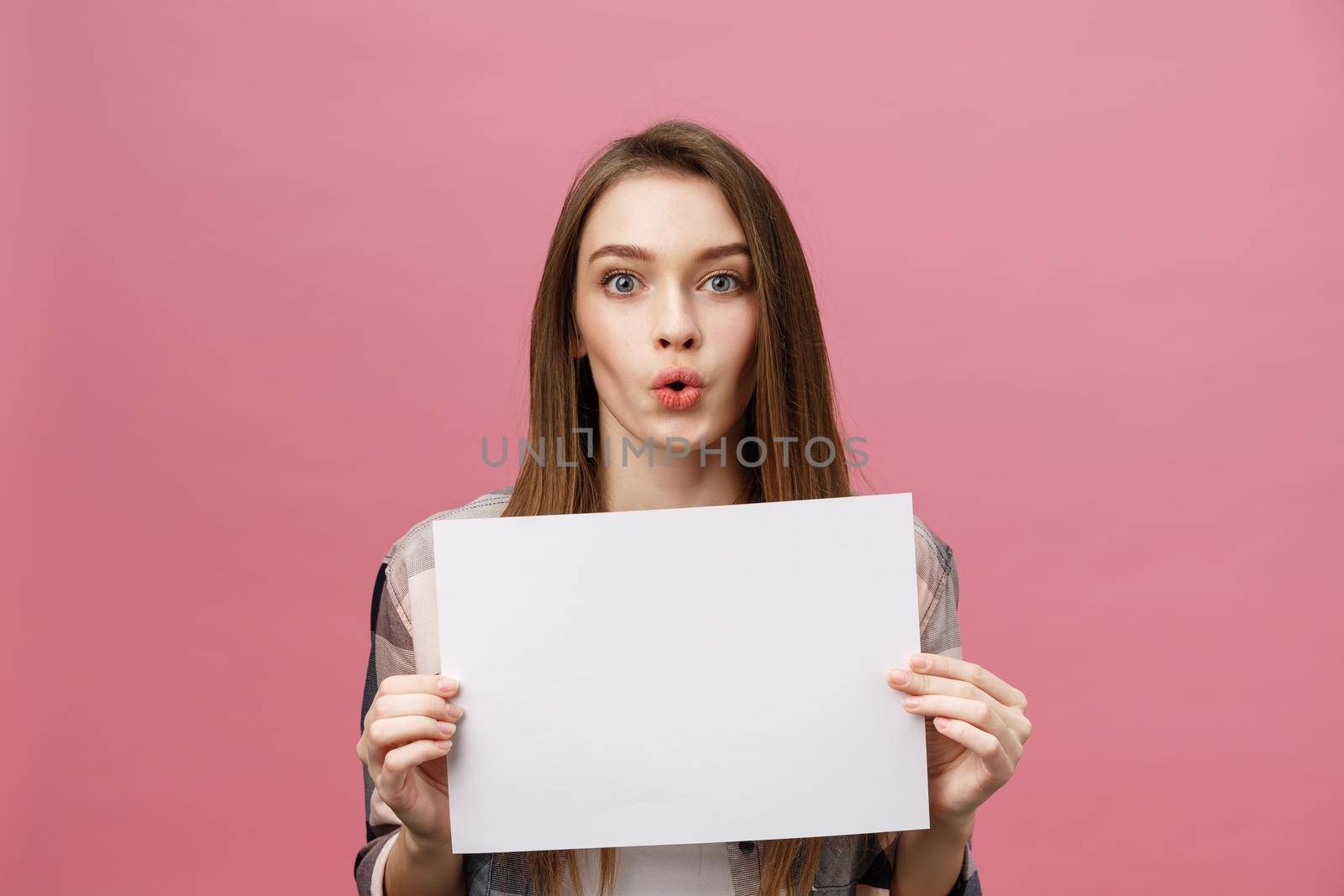 Young caucasian woman holding blank paper sheet over isolated background scared in shock with a surprise face,and excited with fear expression