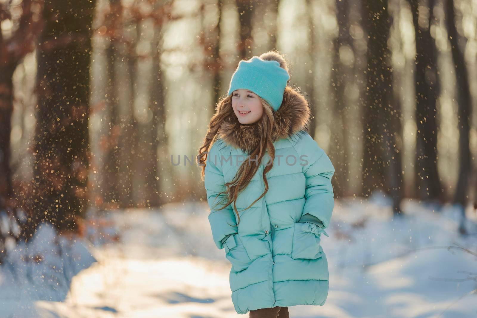 happy girl in turquoise jacket and hat