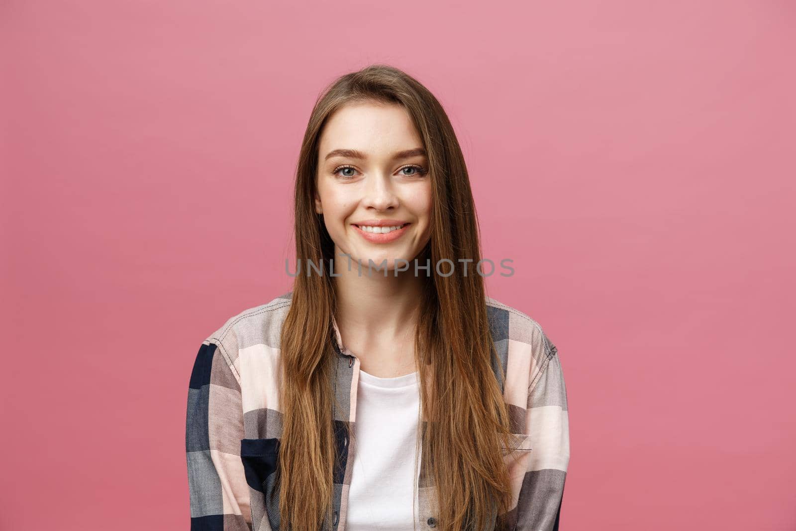 Portrait of beautiful brunette caucasian woman in pink studio.