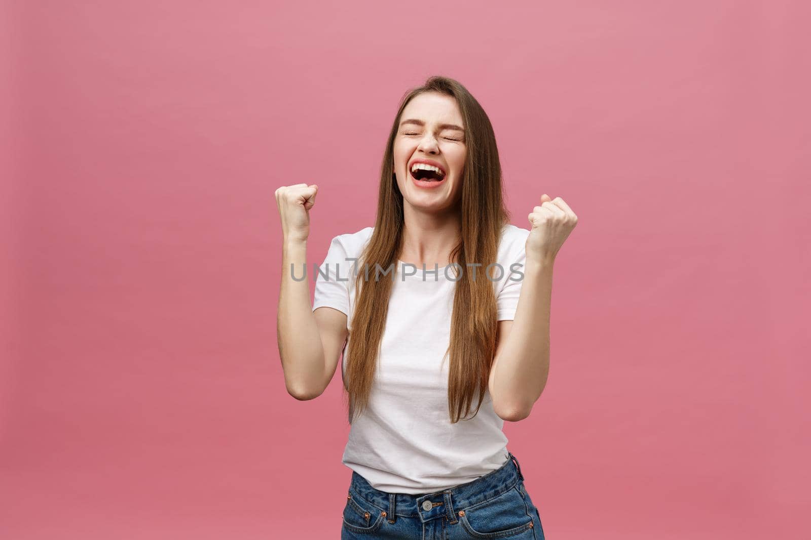 Happy successful young woman with smiling,shouting and celebrating success over pink background by Benzoix