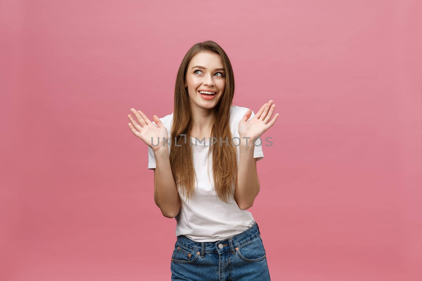 Surprised happy beautiful woman looking in excitement. Isolate over pink background and copy space