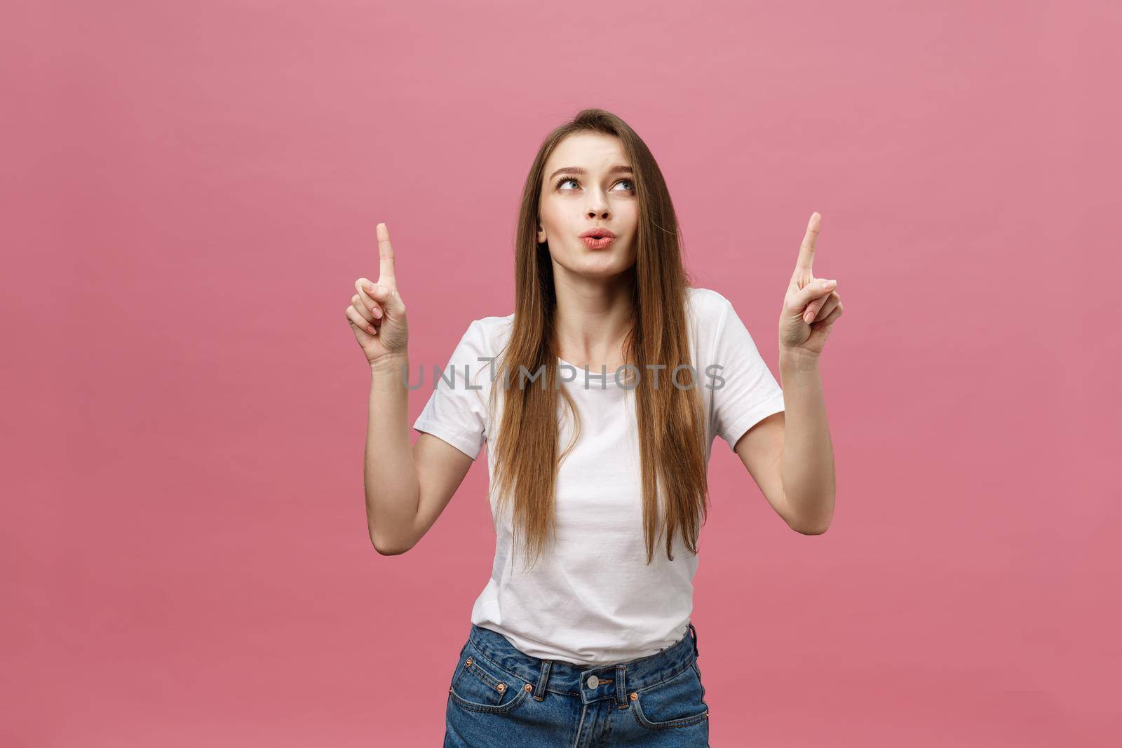 Woman pointing finger at camera and toothy smiling. Expression emotion and feelings concept. Studio shot, isolated on pink background by Benzoix