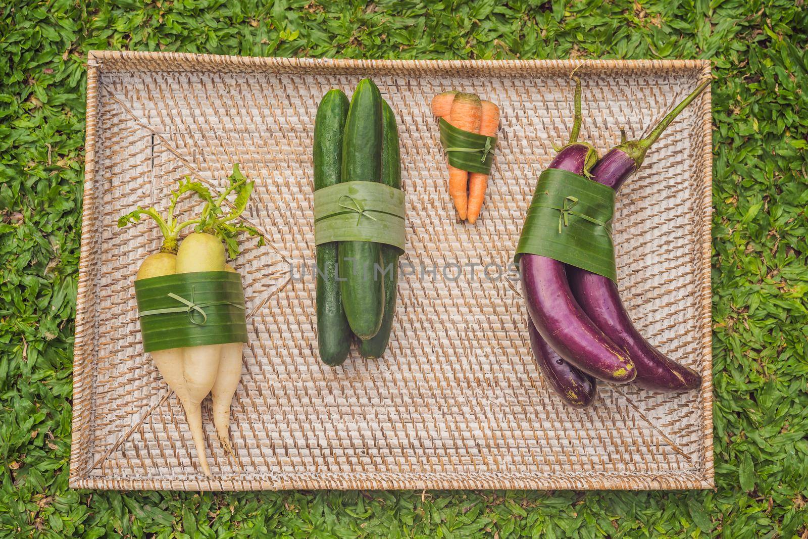 Eco-friendly product packaging concept. Vegetables wrapped in a banana leaf, as an alternative to a plastic bag. Zero waste concept. Alternative packaging.
