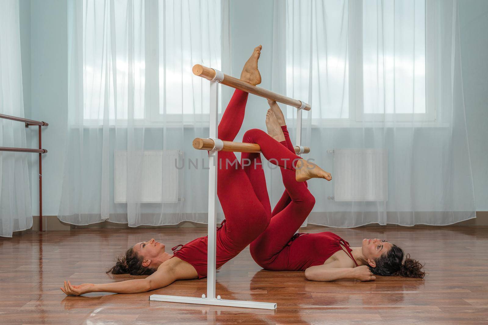 I train with a friend. Two young women train together in a bright training room near a choreographic machine