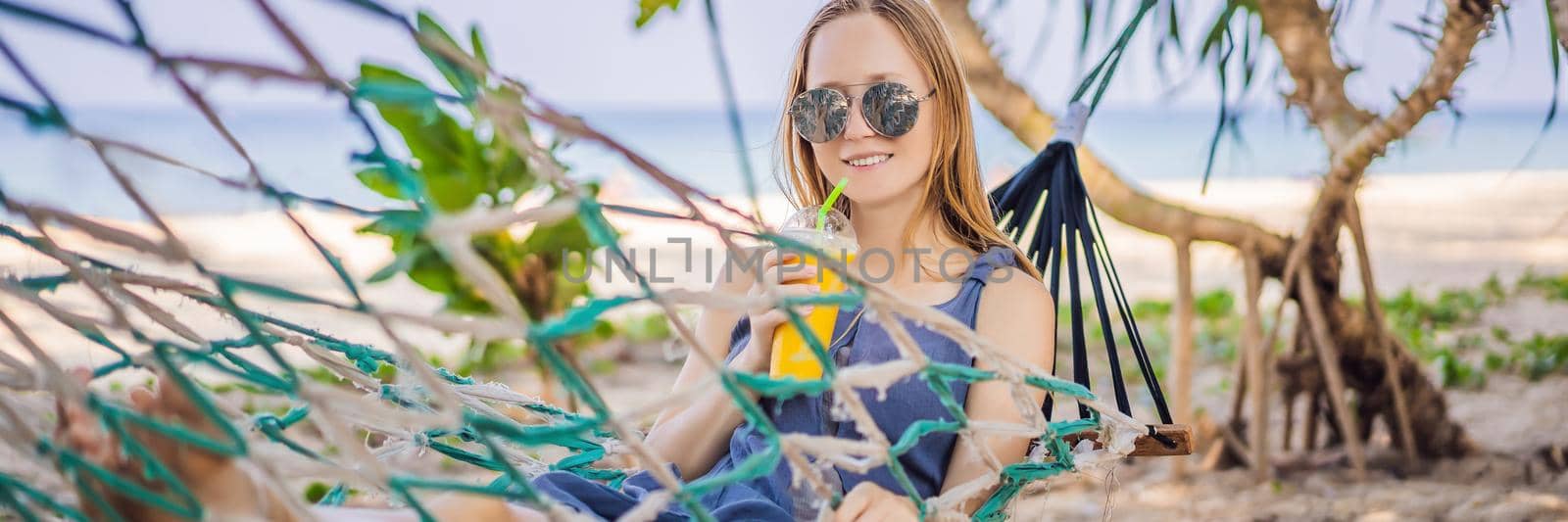 Young woman on the beach in a hammock with a drink BANNER, LONG FORMAT by galitskaya