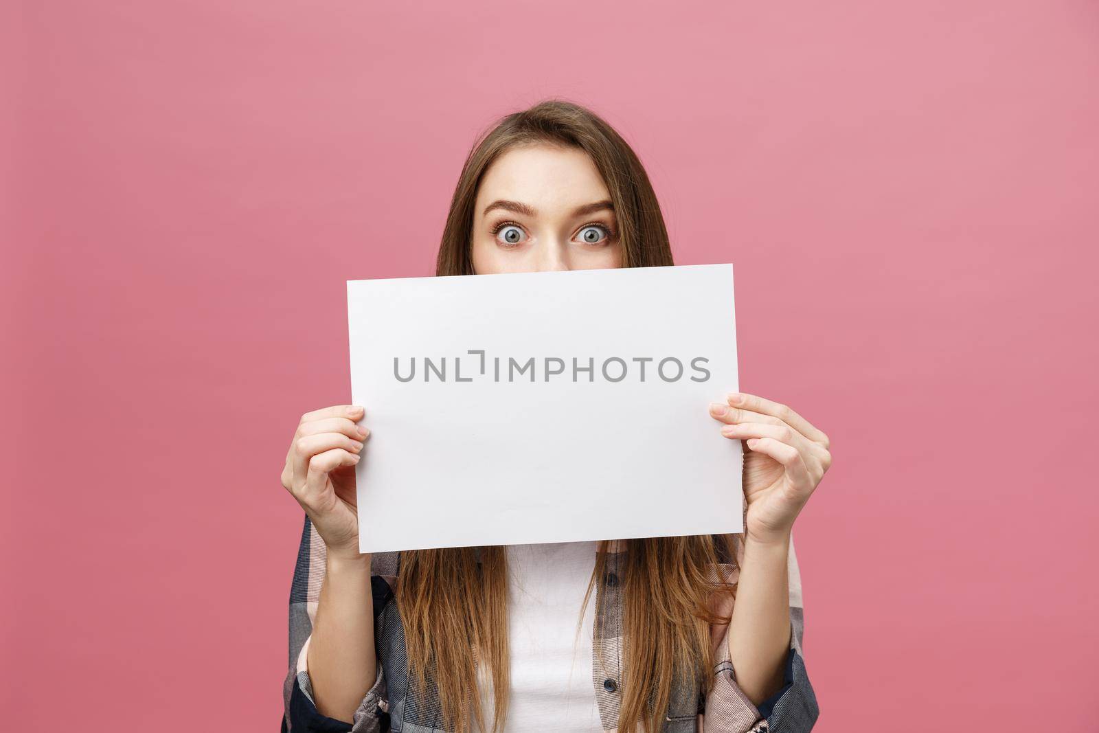 Young caucasian woman holding blank paper sheet over isolated background scared in shock with a surprise face,and excited with fear expression