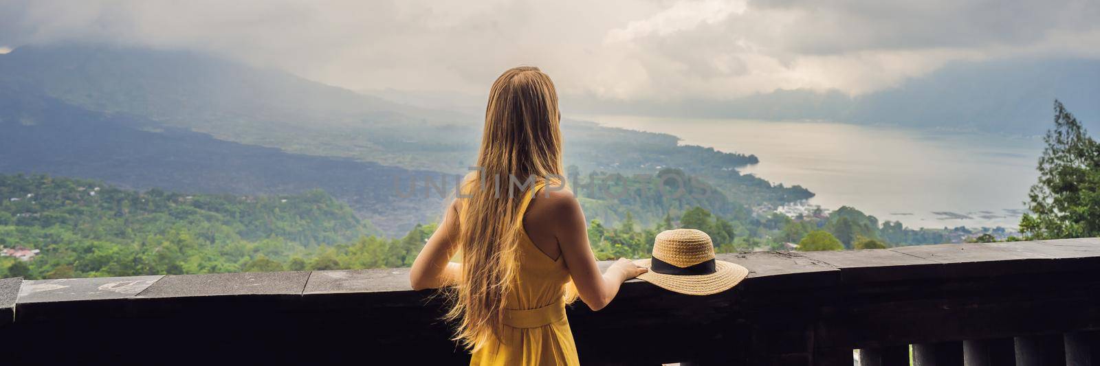 Woman traveler looking at Batur volcano. Indonesia BANNER, LONG FORMAT by galitskaya