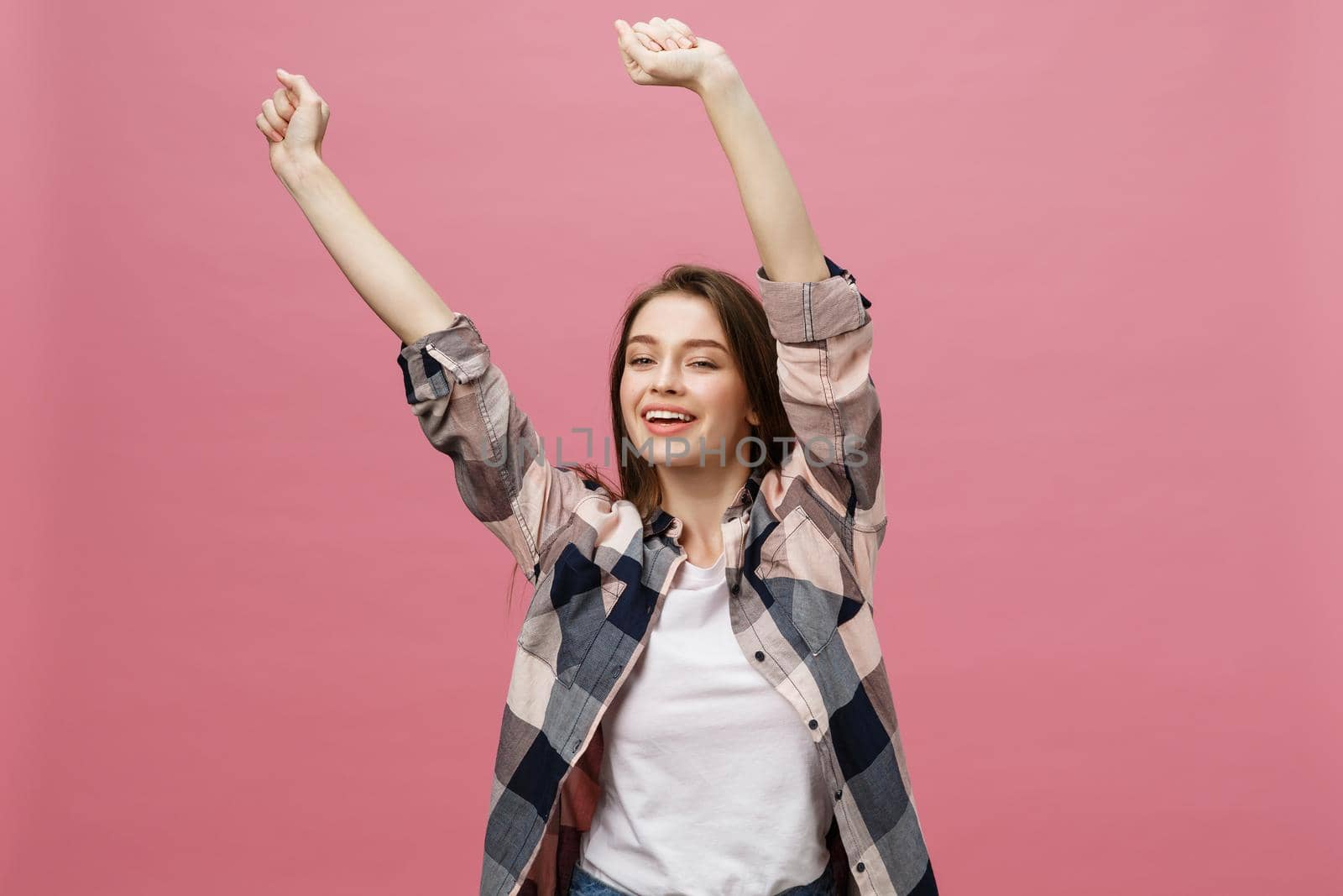 Happy successful young woman with smiling,shouting and celebrating success over pink background.