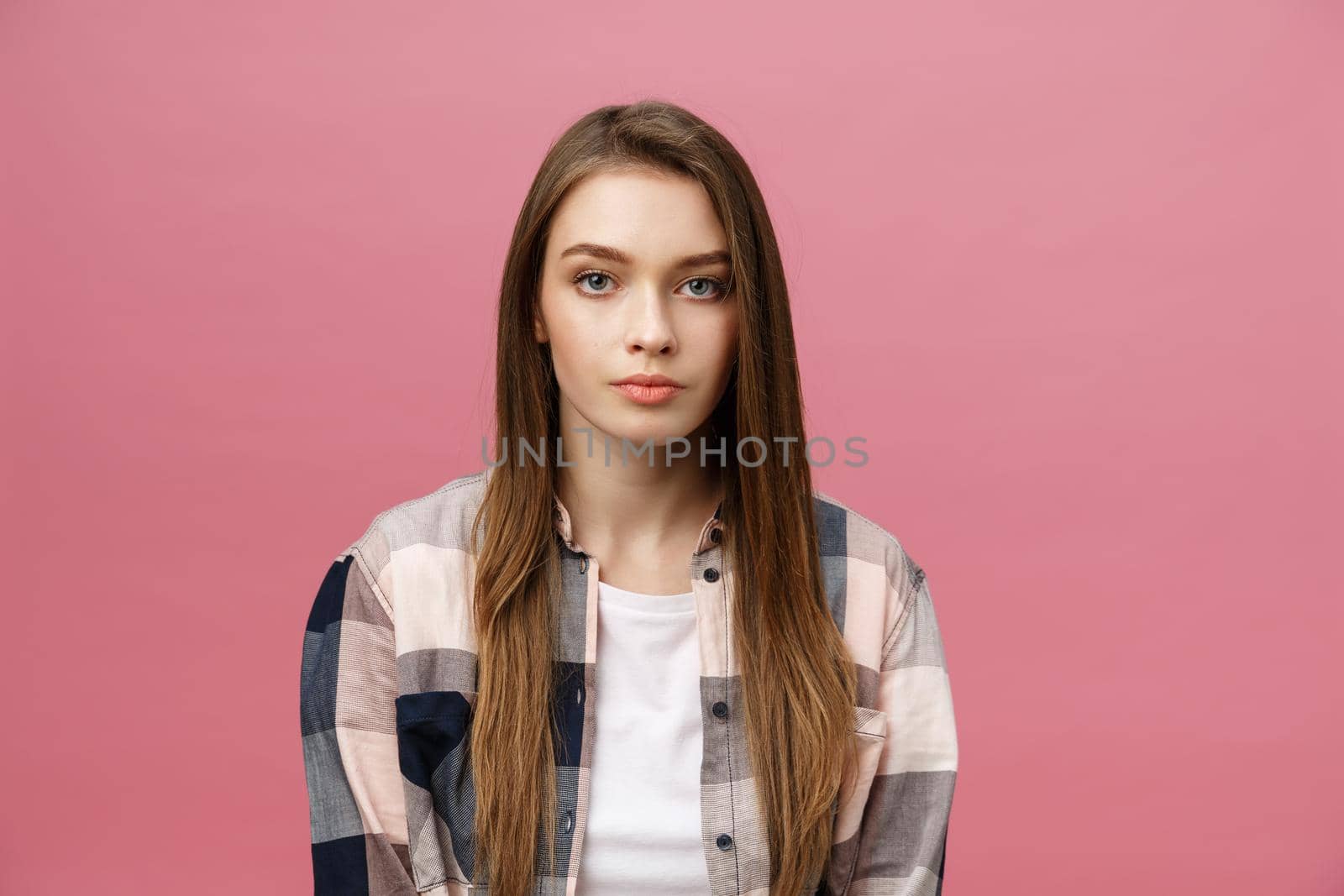 Portrait of beautiful brunette caucasian woman in pink studio.