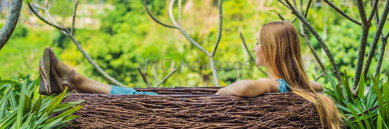 Bali trend, straw nests everywhere. Young tourist enjoying her travel around Bali island, Indonesia. Making a stop on a beautiful hill. Photo in a straw nest, natural environment. Lifestyle BANNER, LONG FORMAT by galitskaya