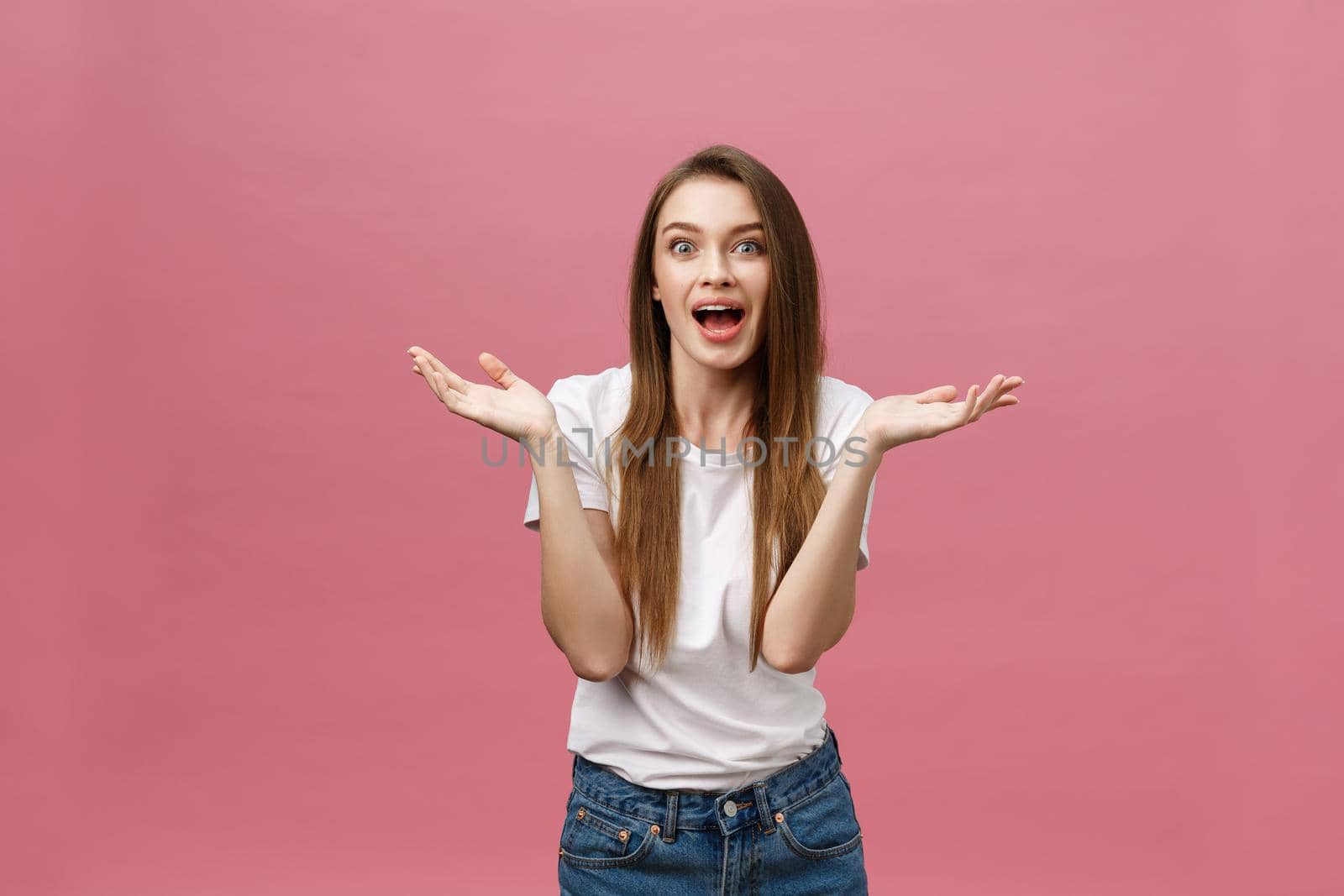 Surprised happy beautiful woman looking in excitement. Isolate over pink background and copy space. by Benzoix