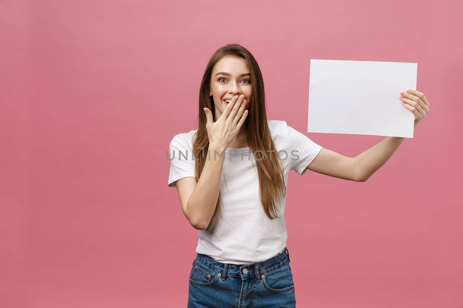 Young caucasian woman holding blank paper sheet over isolated background scared in shock with a surprise face, afraid and excited with fear expression by Benzoix