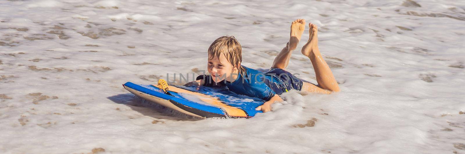 Happy Young boy having fun at the beach on vacation, with Boogie board. BANNER, LONG FORMAT