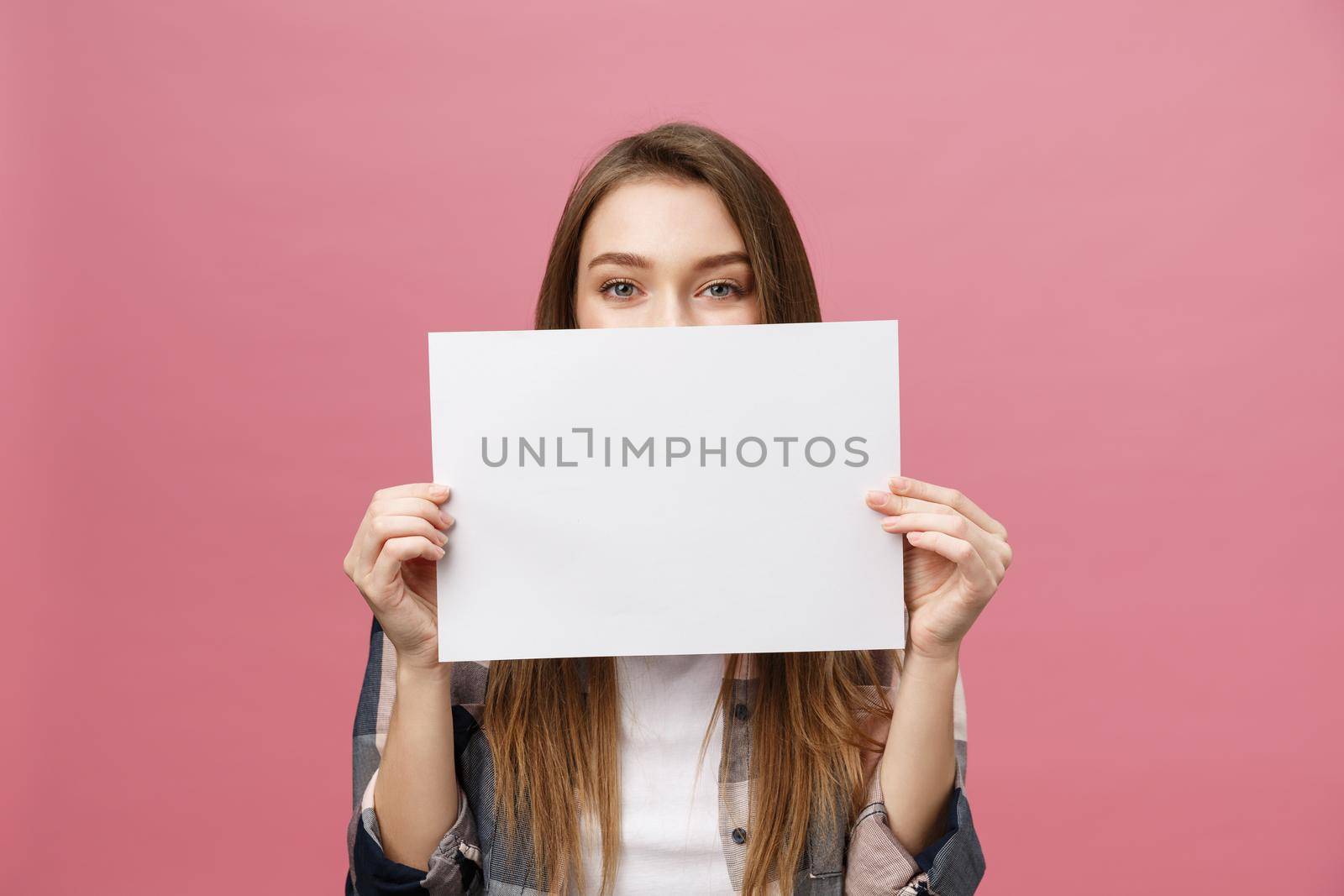 Young caucasian woman holding blank paper sheet over isolated background scared in shock with a surprise face, afraid and excited with fear expression by Benzoix