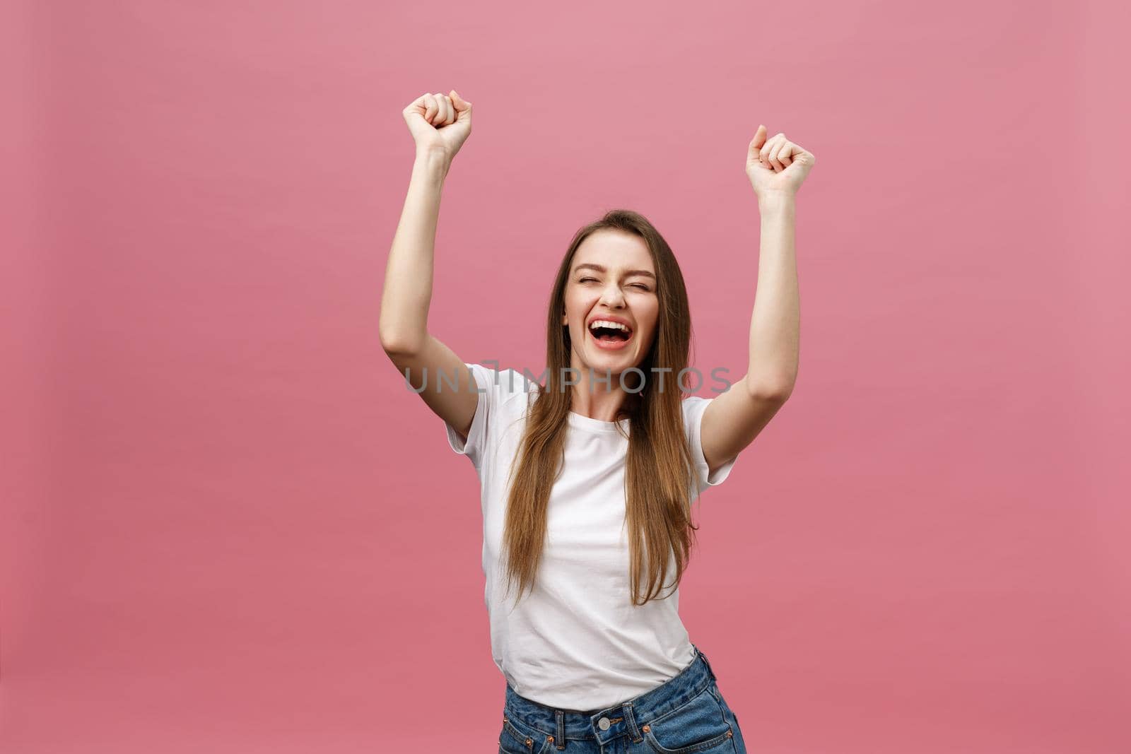 Happy successful young woman with smiling,shouting and celebrating success over pink background by Benzoix