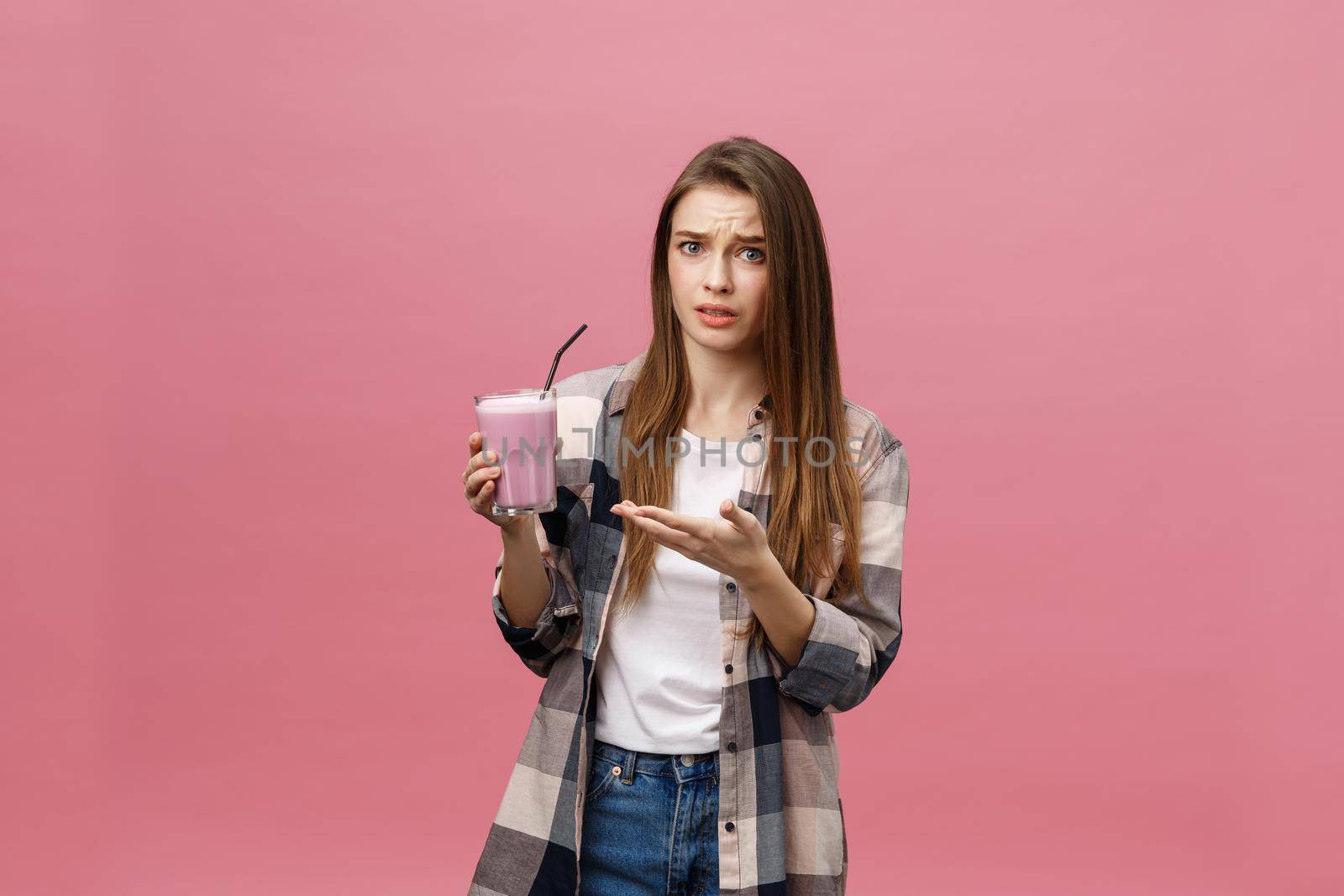 Disappointed young woman drinking smoothie juice. Isolated portrait