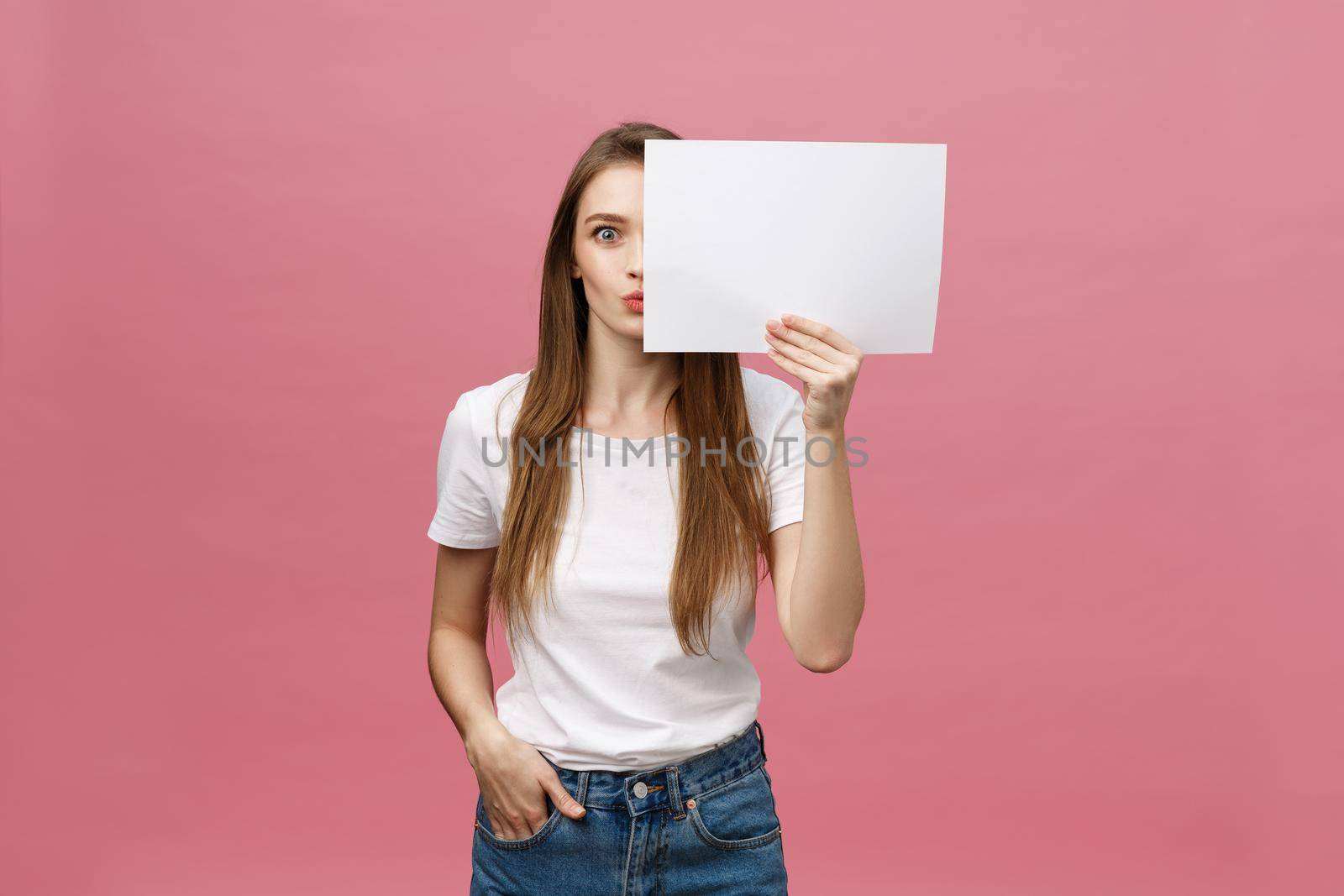 Young caucasian woman holding blank paper sheet over isolated background scared in shock with a surprise face, afraid and excited with fear expression by Benzoix