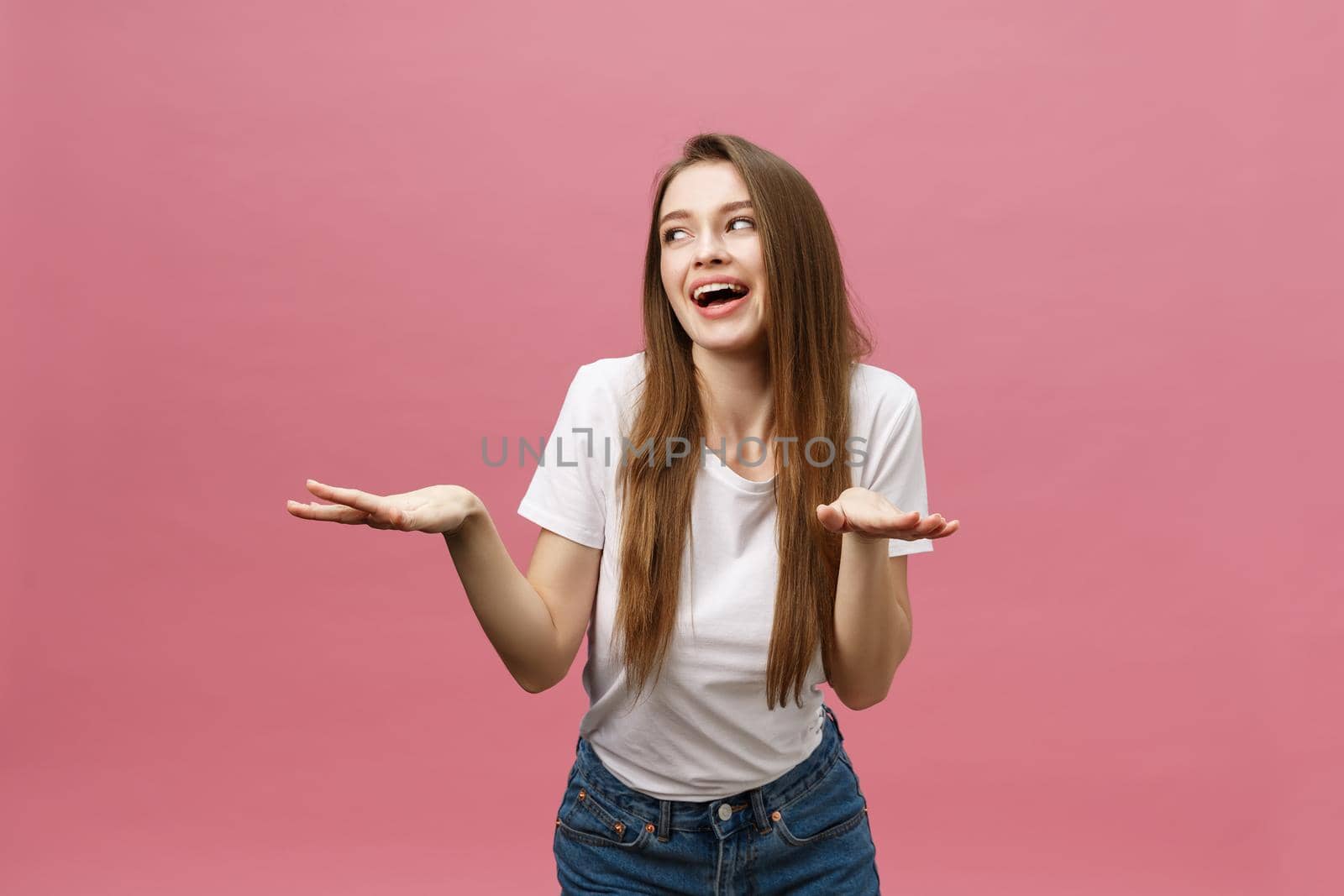 Surprised happy beautiful woman looking in excitement. Isolate over pink background and copy space. by Benzoix