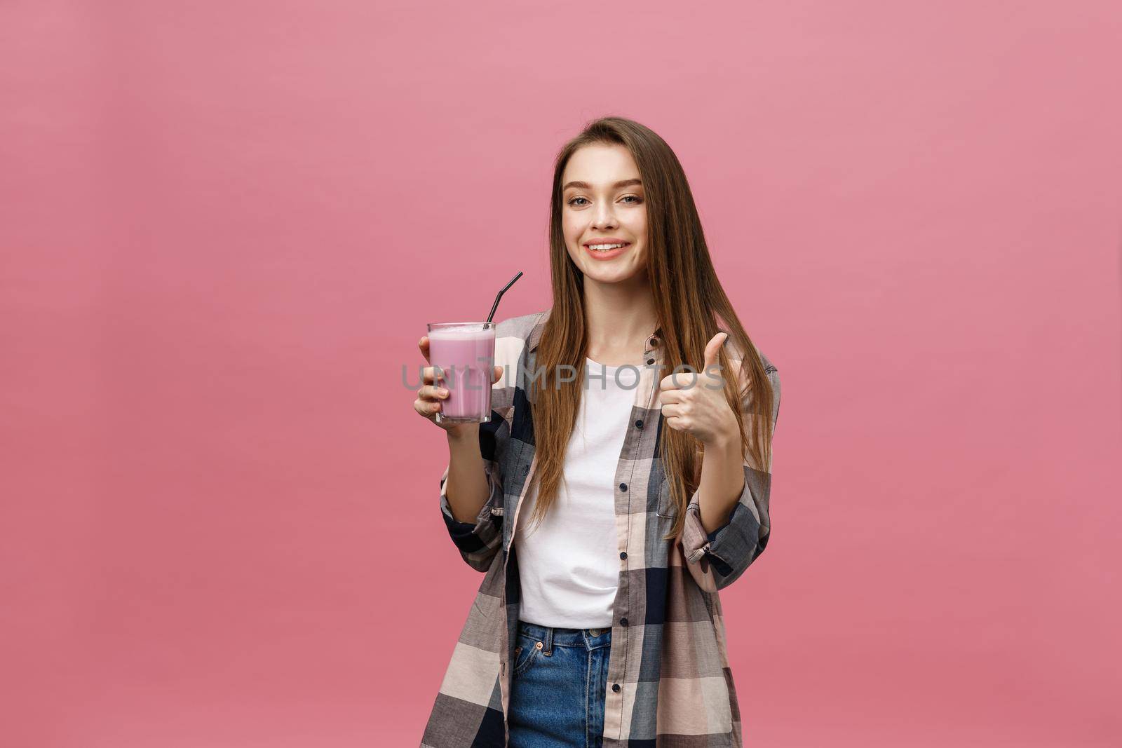 Young woman drinking juice smoothie with straw. Isolated studio portrait. by Benzoix