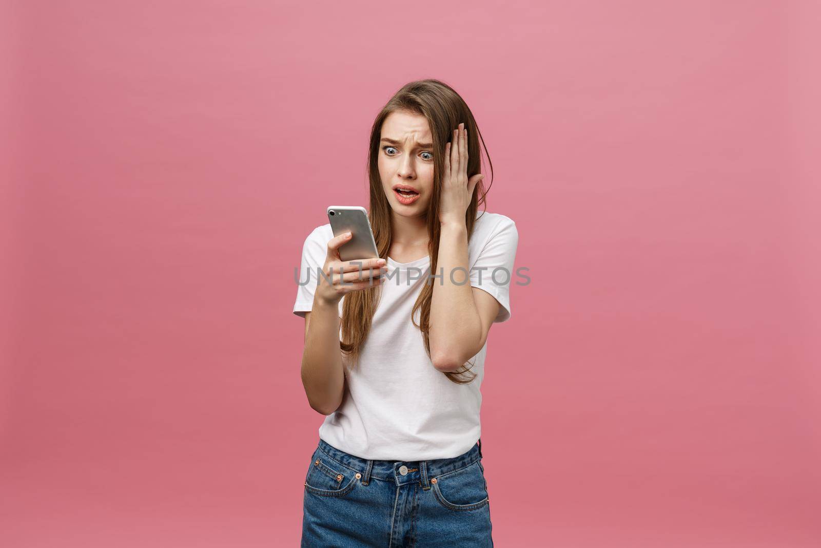 Serious young woman talking on phone isolated on pink. Copy space and fashion. Mock up