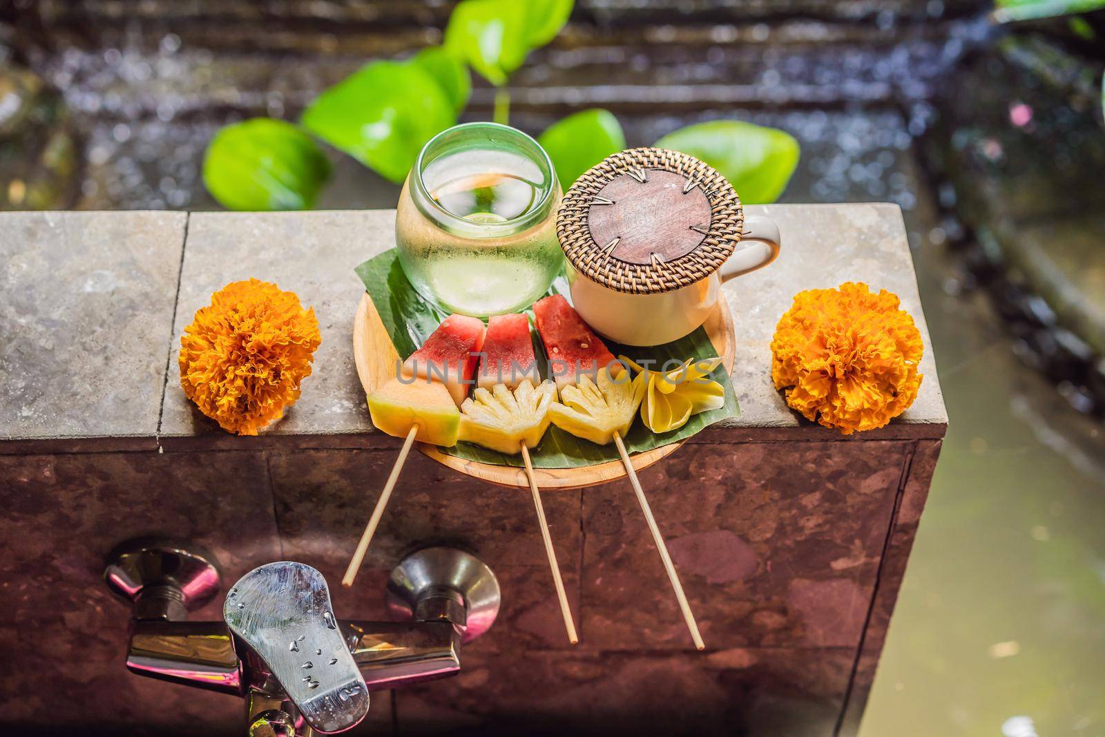 Sliced Mango Water Melon Papaya Melon Fruits on Wet Green Palm Leaf Decorated Pink Frangipani Flower Tropical Nature Background.