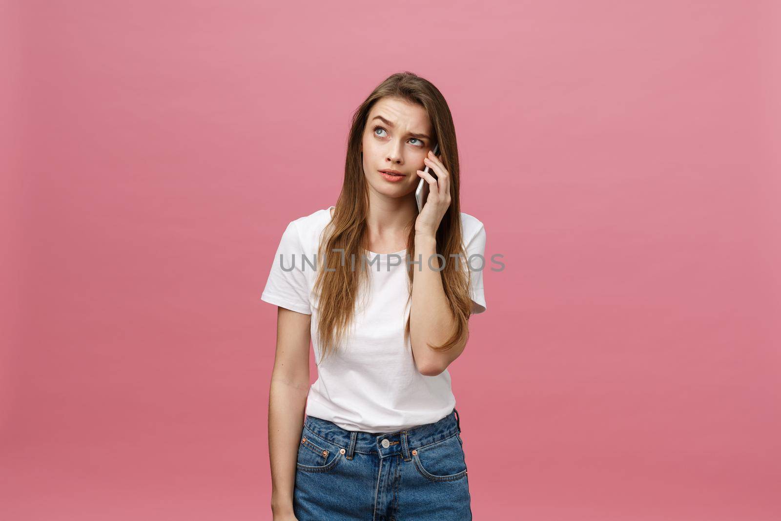 Serious young woman talking on phone isolated on pink. Copy space and fashion. Mock up. by Benzoix