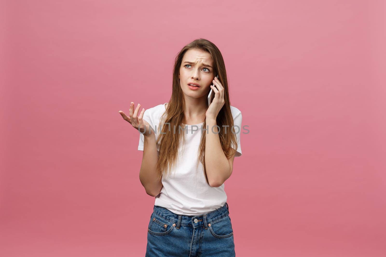 Serious young woman talking on phone isolated on pink. Copy space and fashion. Mock up. by Benzoix