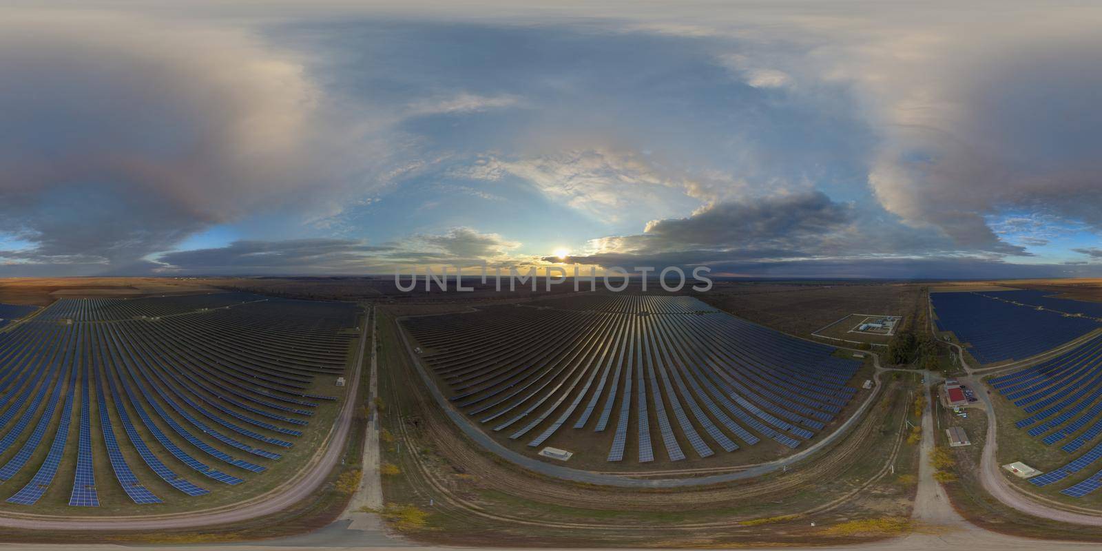 Aerial top view of a solar panels power plant. Photovoltaic solar panels at sunrise and sunset in countryside from above. Modern technology, climate care, earth saving, renewable energy concept