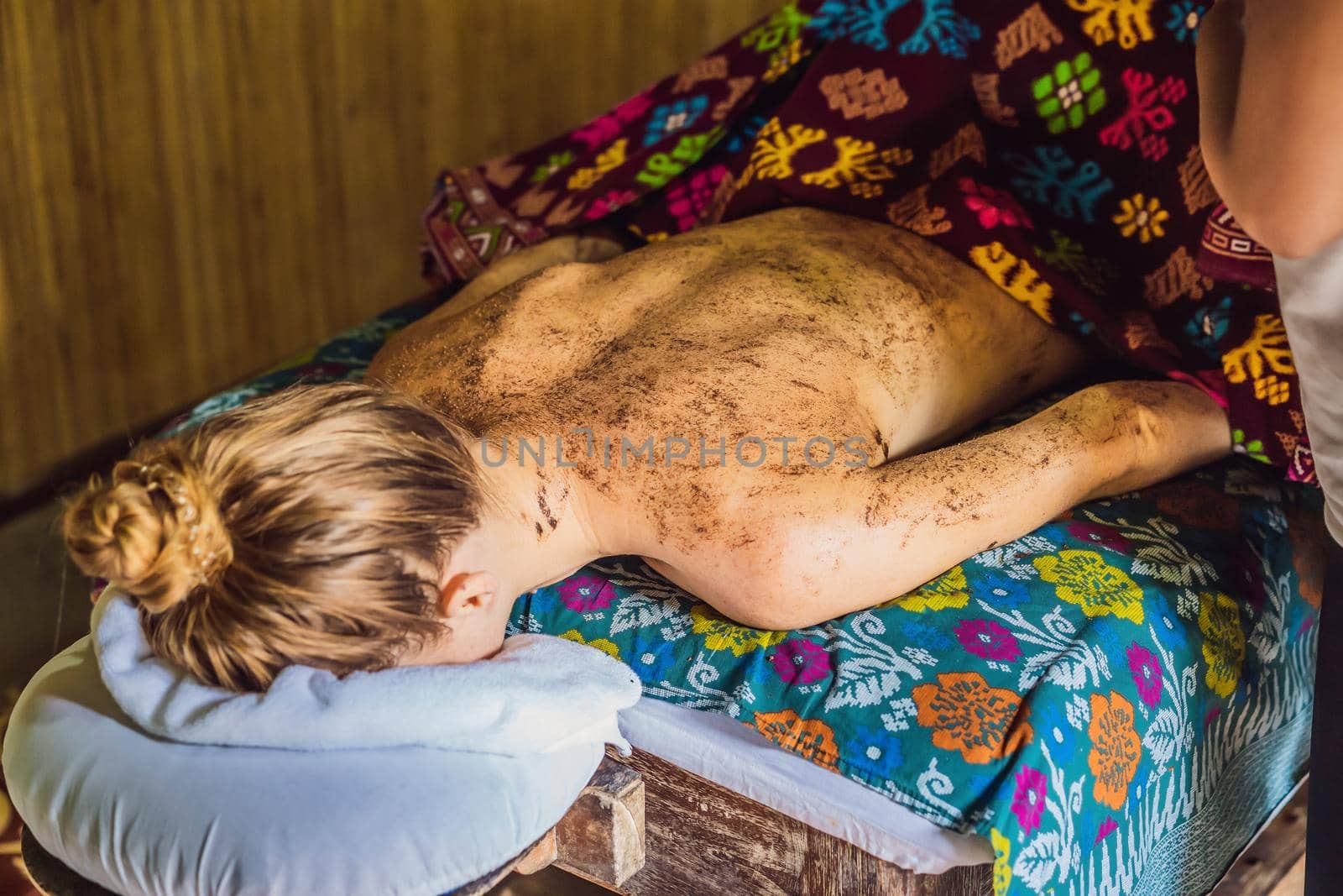 Young beautiful relaxing woman getting spa massage of shoulder in beauty salon.