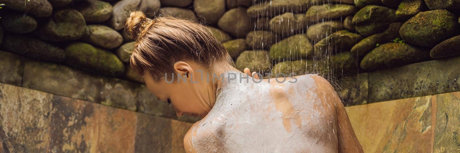 Back view of beautiful naked young woman taking shower in bathroom. BANNER, LONG FORMAT