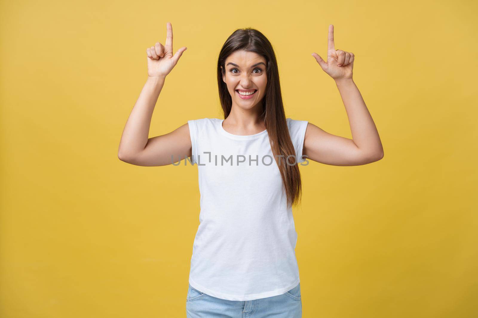 Profile of a woman pointing on copy space for an advertisement isolated on a yellow background.