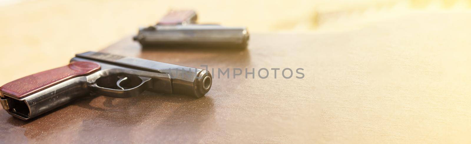 The gun lies on a table on old village boards, legalization of weapons. Crime problems. Weapons for sports and self-defense. Conceptual of violence, homicide, crime and burglary.