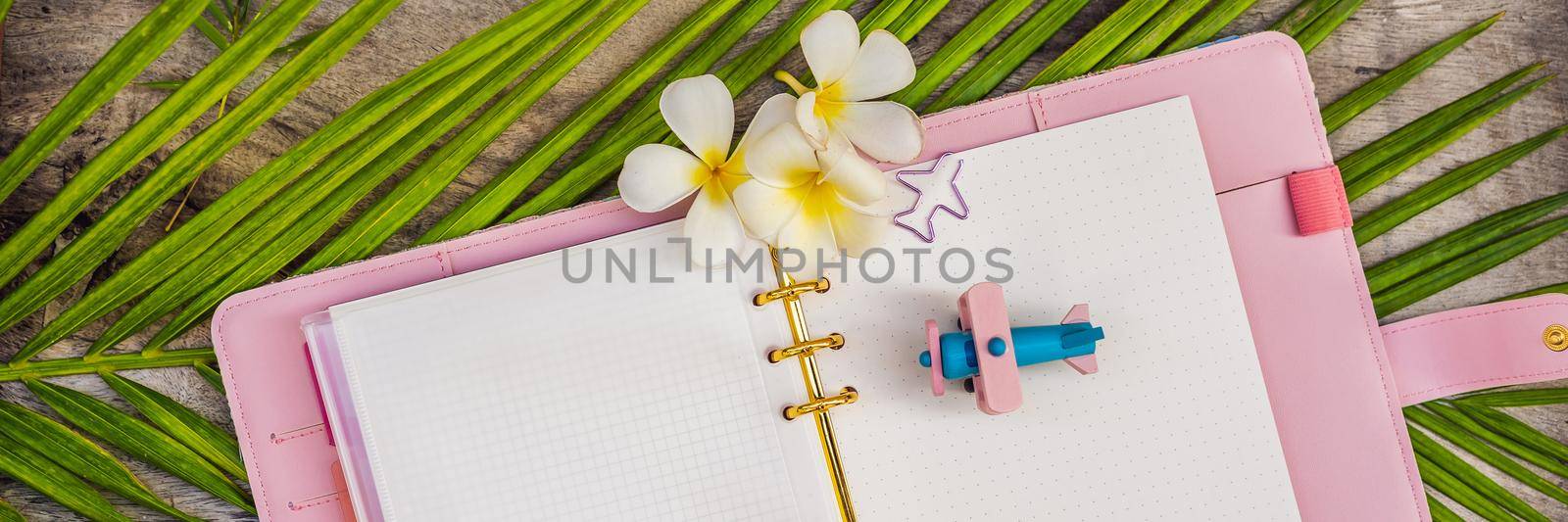 Notepad and stationery on wooden background. Planner for business and study. Fans of stationery. Travel planning notebook. Travel concept BANNER, LONG FORMAT by galitskaya