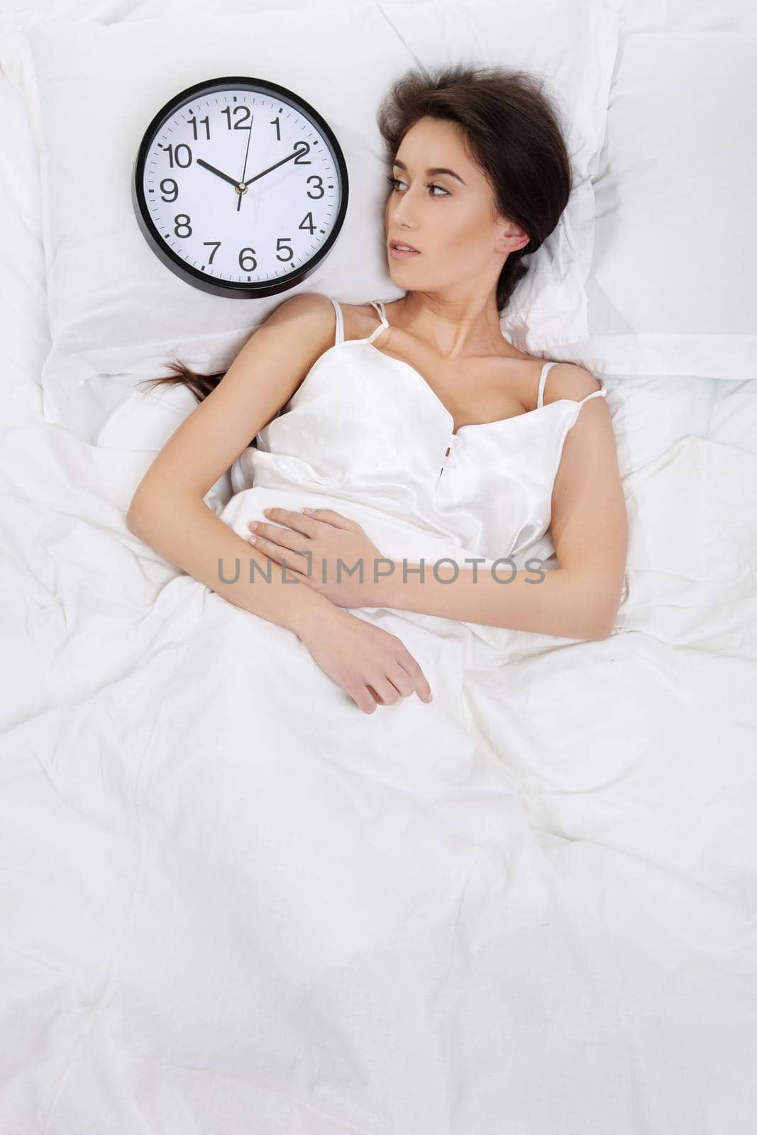 Happy woman waking up and turning off the alarm clock
