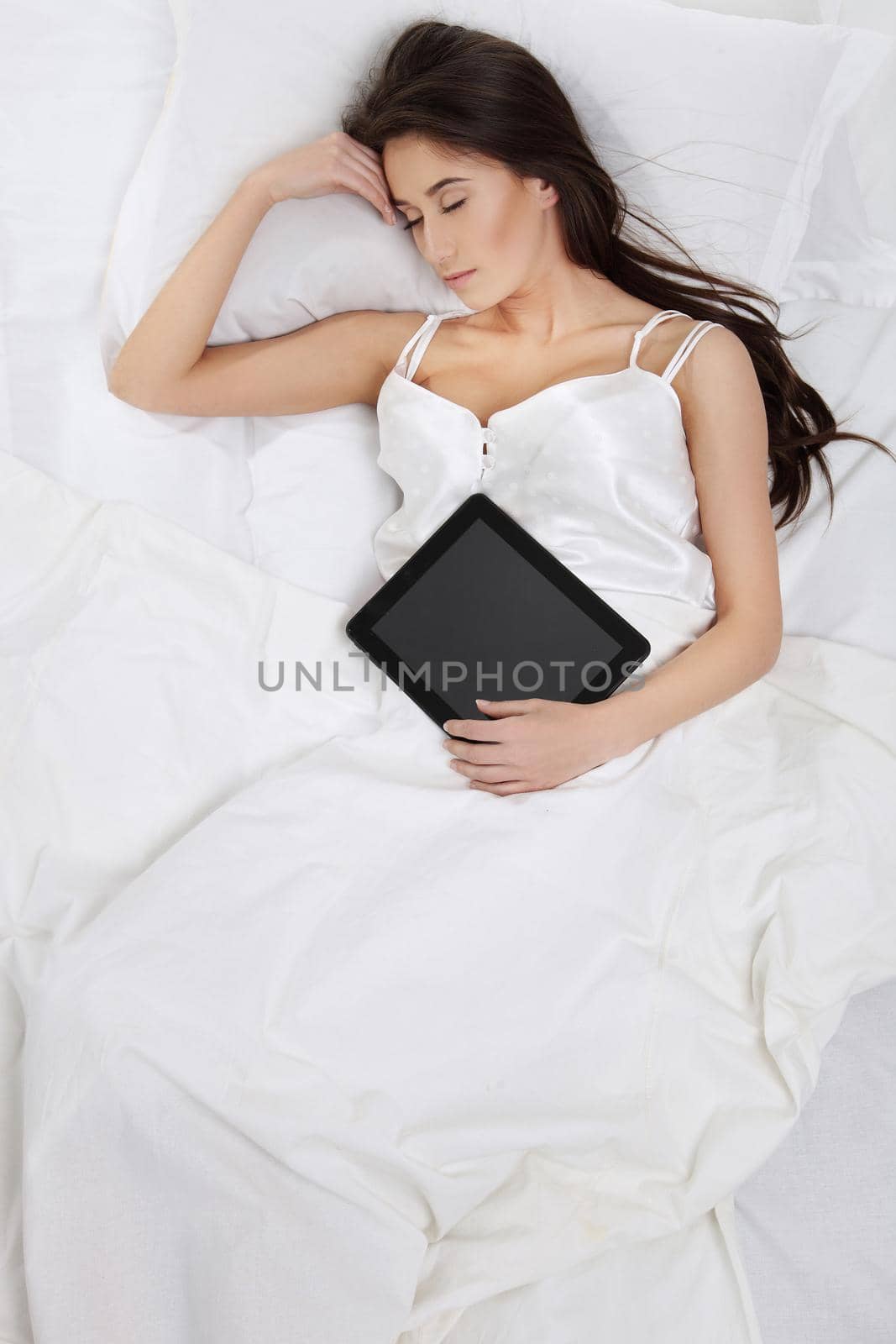 Woman lying in bed with her tablet PC