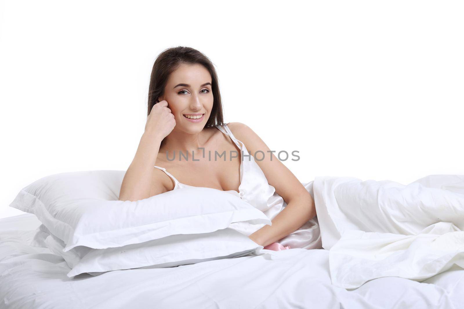 young beautiful girl woke up and sitting on a bed