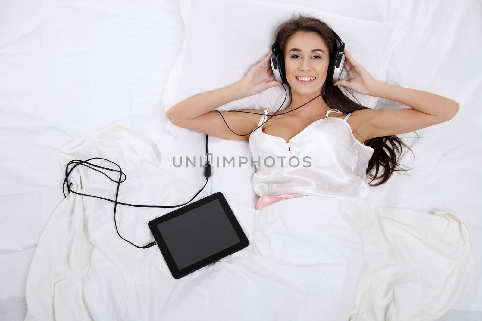 Woman lying in bed with her tablet PC