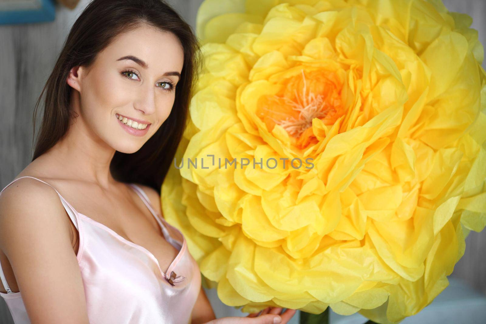 Fashion art photo of beautiful lady with big flower. Home interior. Morning