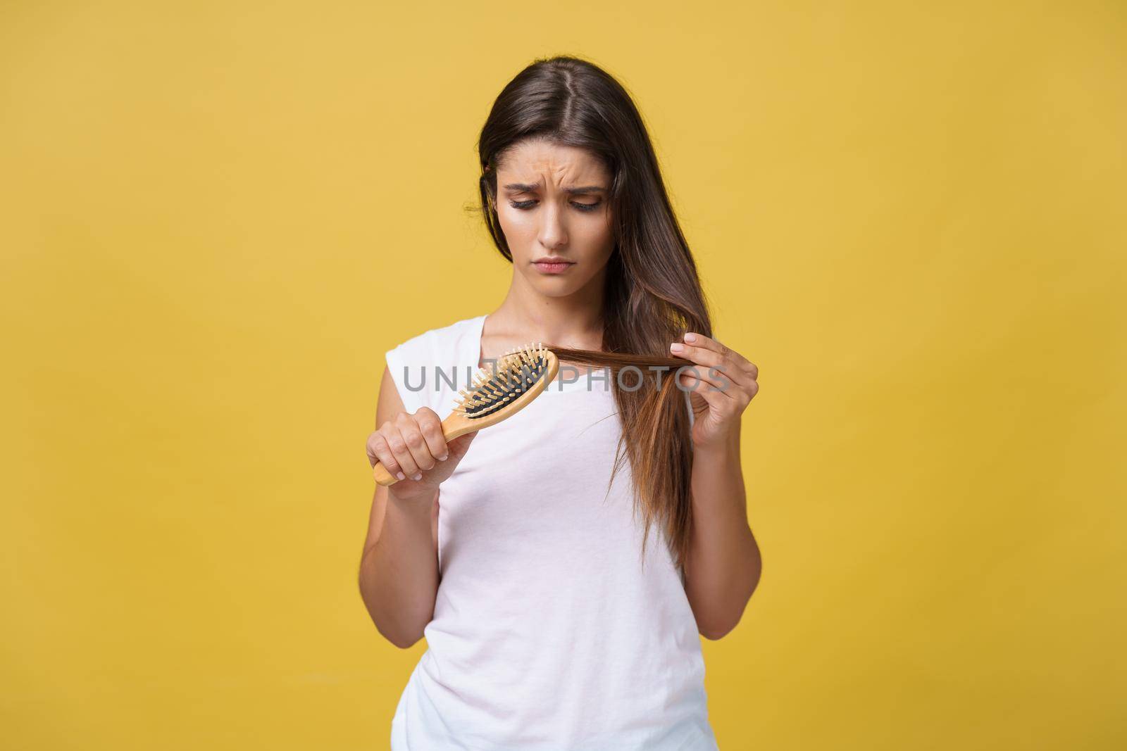 Woman hand holding her long hair with looking at damaged splitting ends of hair care problems. by Benzoix