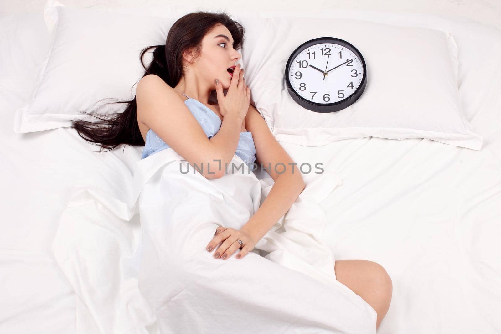 Young beautiful woman with alarm clock