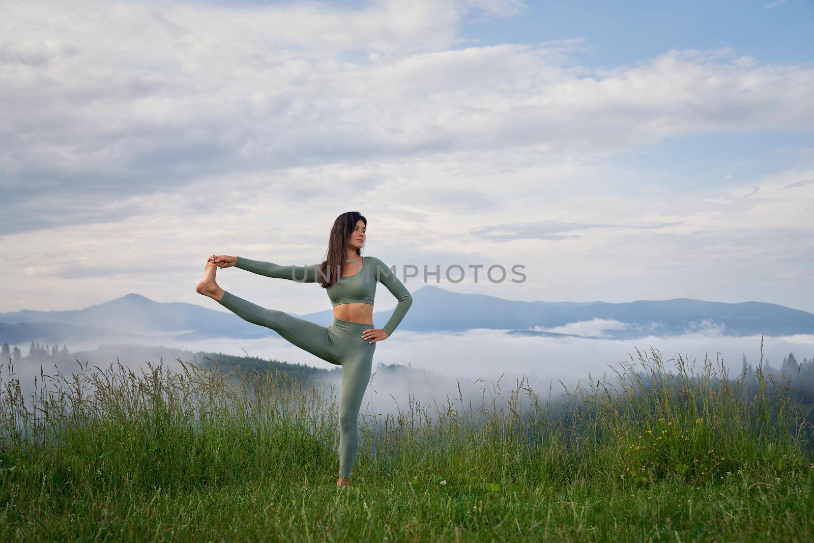 Woman stretching legs during morning time outdoors by SerhiiBobyk