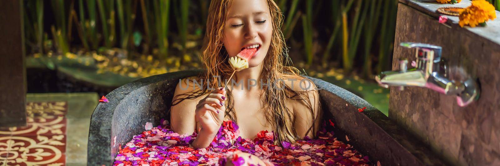 Attractive Young woman in bath with petals of tropical flowers and aroma oils. Spa treatments for skin rejuvenation. Alluring woman in Spa salon. Girl relaxing in bathtub with flower petals. Luxury BANNER, LONG FORMAT by galitskaya