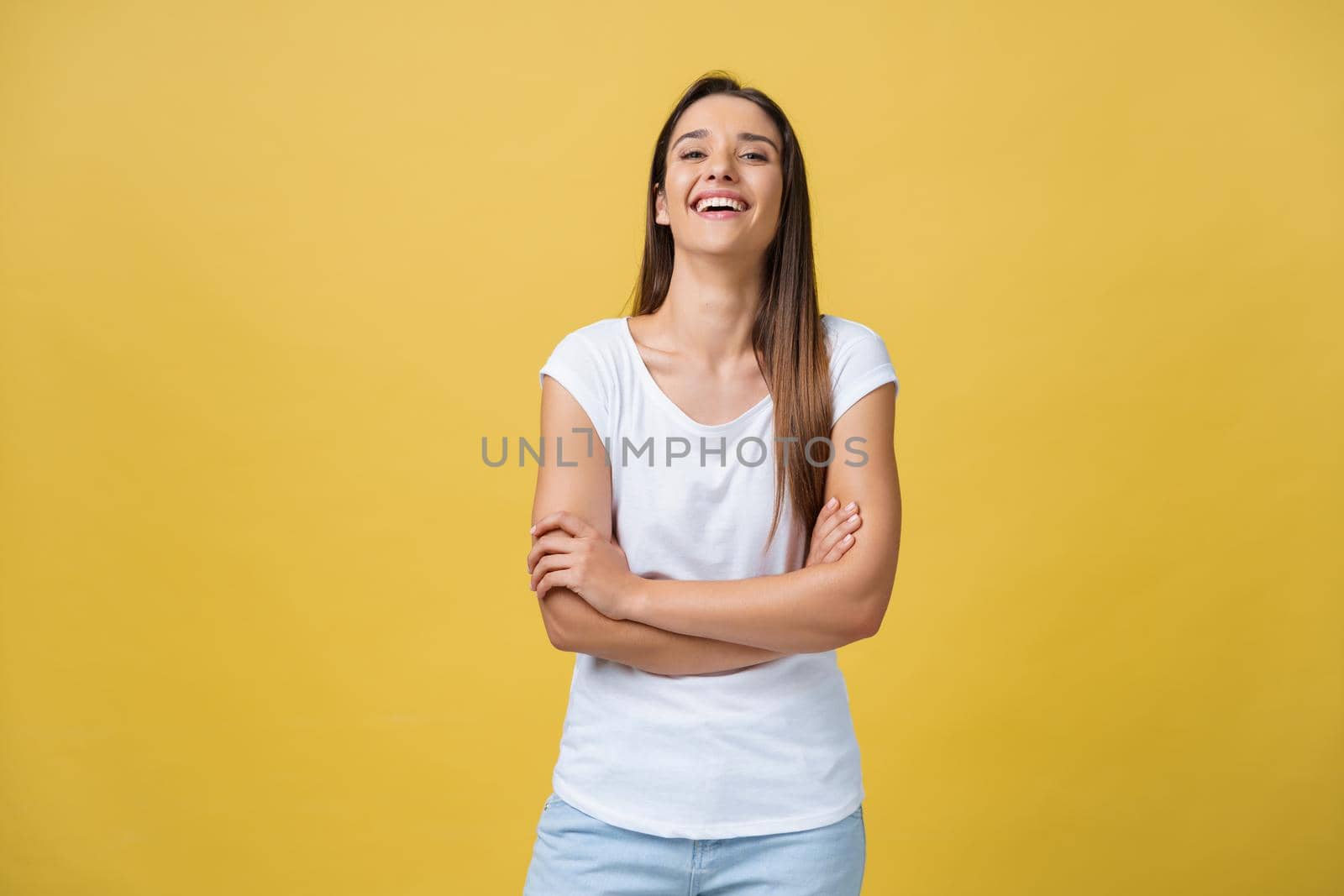 Portrait young beautiful caucasian girl with an white shirt laughing over yellow background