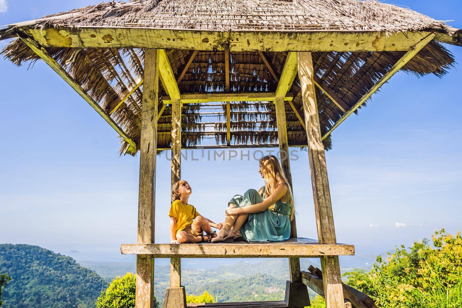 Mom and son in a gazebo in Bali. Traveling with kids concept. Kids Friendly places.